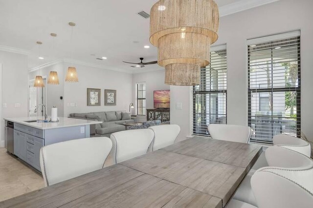 dining room with crown molding, sink, and ceiling fan