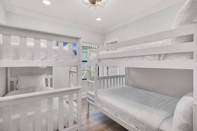 bedroom with wood-type flooring and ornamental molding