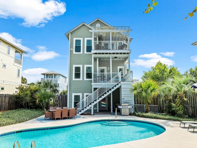 back of property featuring a fenced in pool and a patio area