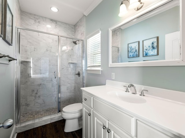 bathroom featuring hardwood / wood-style flooring, toilet, crown molding, vanity, and an enclosed shower