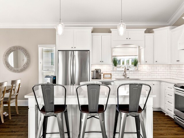 28 Sandcastle Ct, Santa Rosa Beach, FL 32459 - kitchen featuring appliances with stainless steel finishes, a kitchen breakfast bar, ornamental molding, and a sink