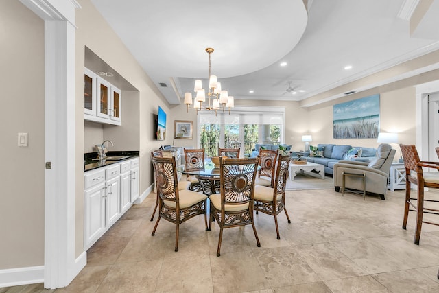 dining space featuring a notable chandelier, sink, and crown molding