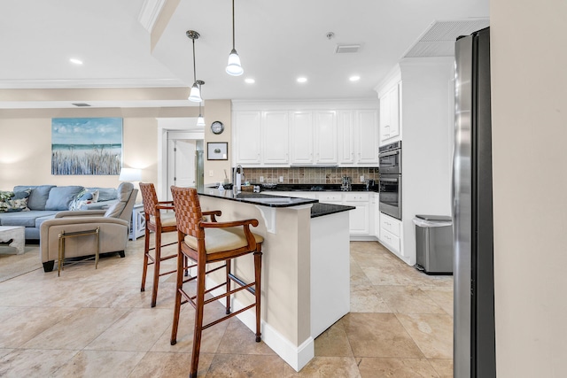 kitchen with decorative backsplash, a kitchen breakfast bar, white cabinetry, pendant lighting, and stainless steel appliances