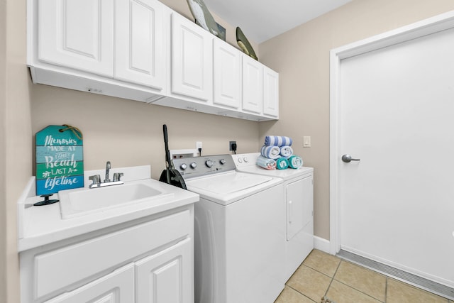 washroom featuring sink, cabinets, light tile patterned floors, and separate washer and dryer