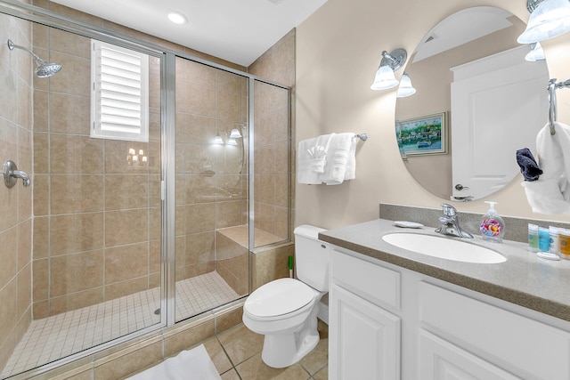 bathroom featuring vanity, toilet, tile patterned flooring, and an enclosed shower