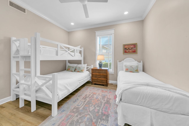 bedroom with crown molding, wood-type flooring, and ceiling fan