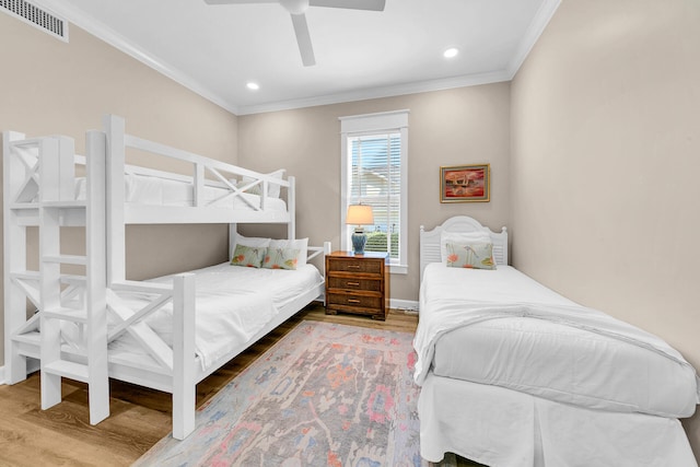 bedroom featuring ornamental molding, hardwood / wood-style flooring, and ceiling fan