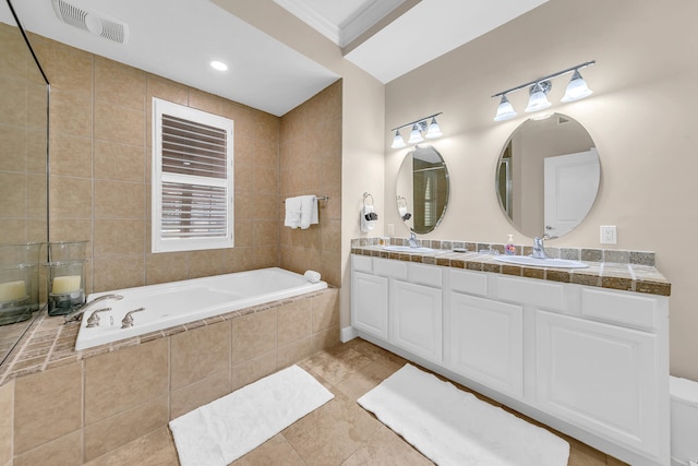 bathroom featuring vanity, tiled bath, crown molding, and tile patterned floors