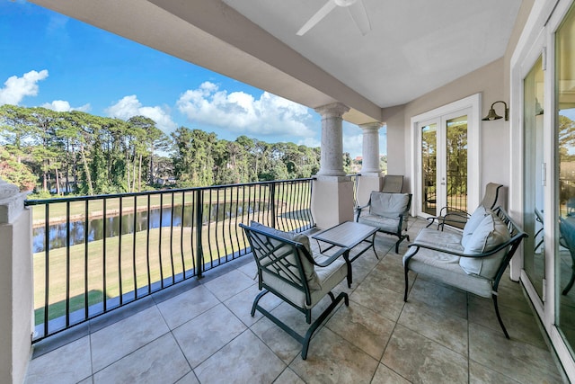 balcony with a water view and ceiling fan