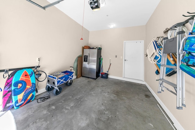 garage featuring a garage door opener and stainless steel refrigerator with ice dispenser