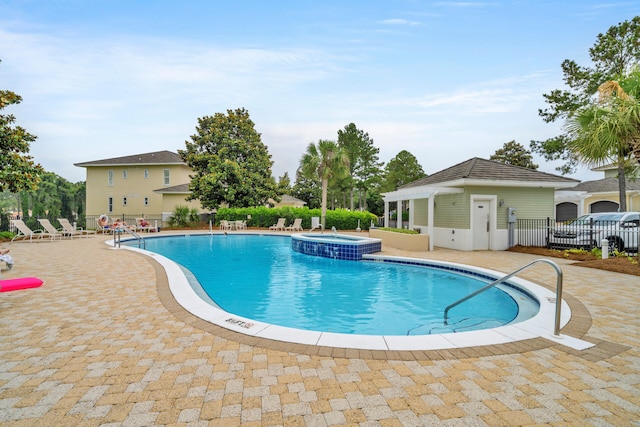 view of swimming pool with a hot tub and a patio area