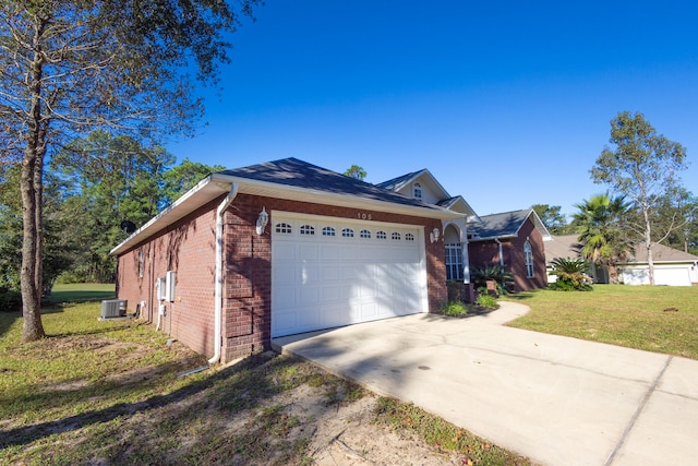 view of front of house with central air condition unit, a front yard, and a garage