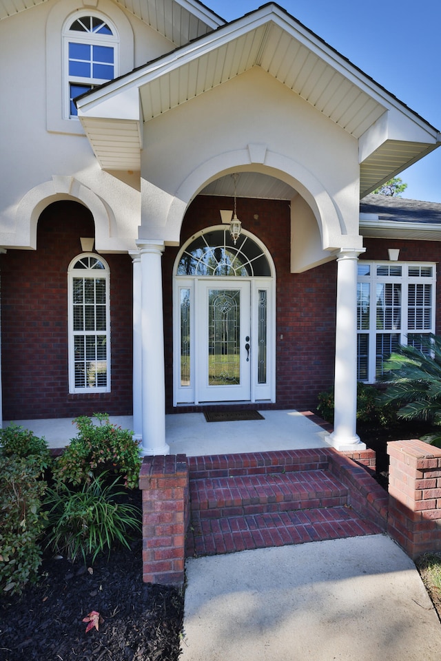 view of exterior entry featuring covered porch