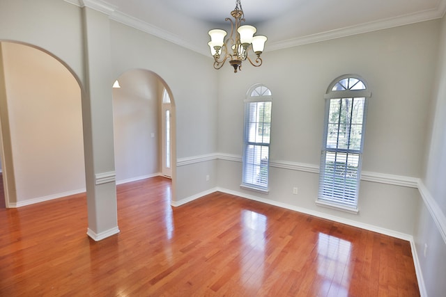 spare room featuring ornamental molding, a chandelier, and hardwood / wood-style flooring