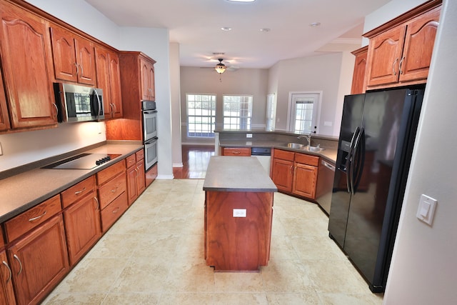 kitchen featuring black appliances, ceiling fan, a center island, sink, and kitchen peninsula