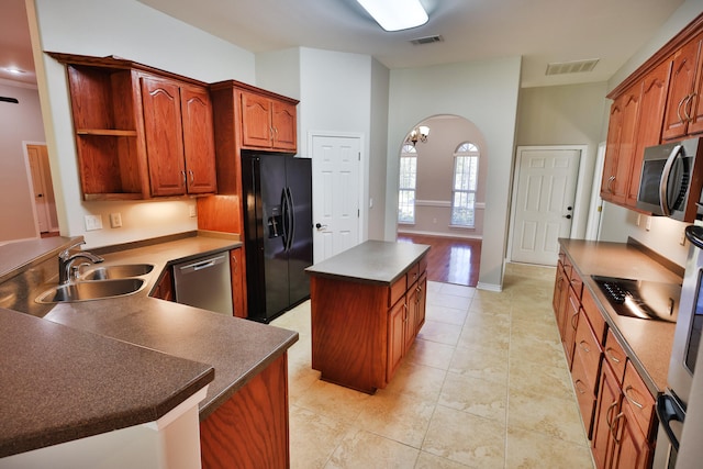 kitchen with light tile patterned floors, stainless steel appliances, sink, and a center island