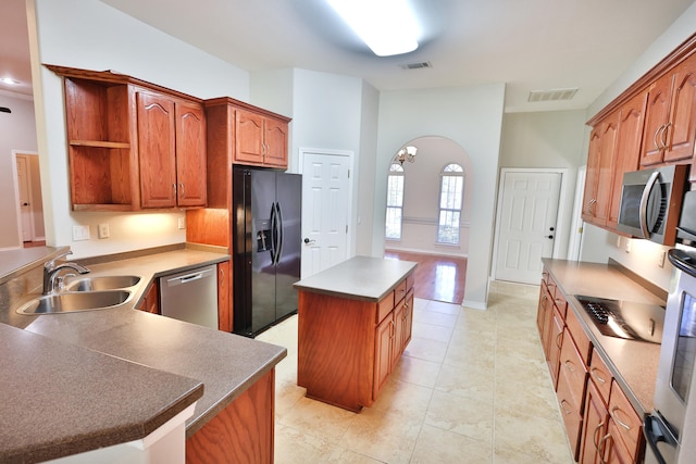 kitchen with stainless steel appliances, light tile patterned flooring, a kitchen island, and sink