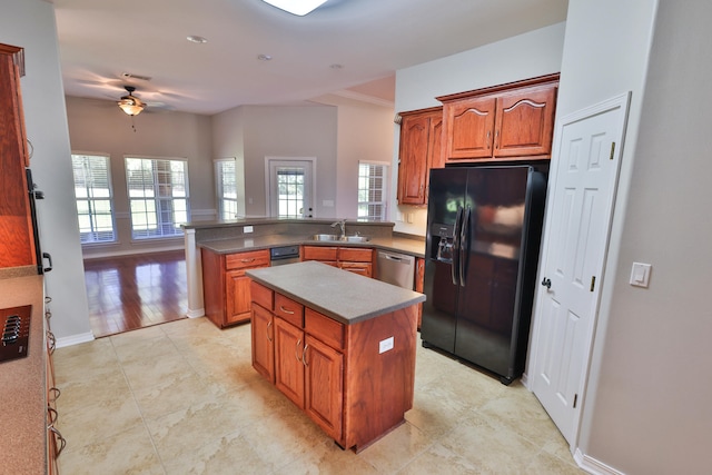 kitchen with ceiling fan, a center island, sink, black fridge, and kitchen peninsula