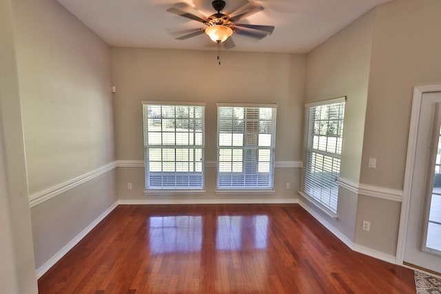 empty room with ceiling fan and dark hardwood / wood-style flooring