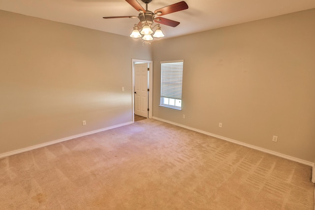 carpeted spare room featuring ceiling fan