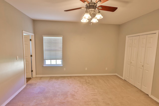 unfurnished bedroom with ceiling fan, light colored carpet, and a closet