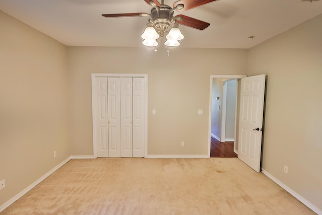 unfurnished bedroom featuring ceiling fan, a closet, and light colored carpet