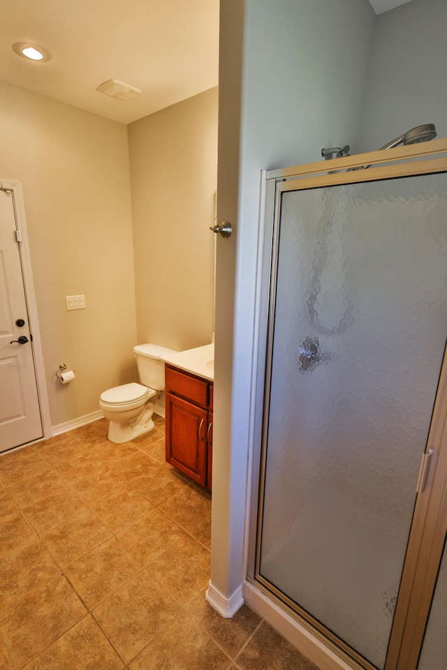 bathroom featuring walk in shower, vanity, tile patterned flooring, and toilet