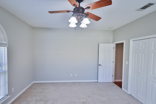 interior space featuring a closet, light colored carpet, and ceiling fan