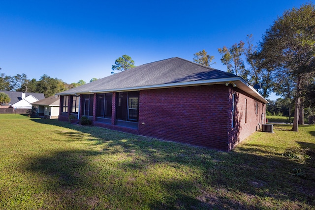 view of home's exterior with a sunroom and a yard