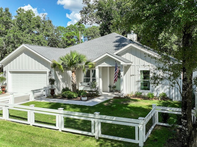 modern farmhouse featuring a garage and a front lawn