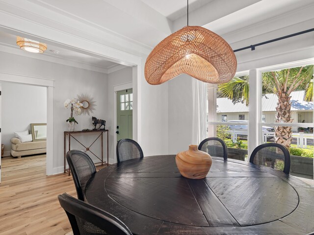 dining room with crown molding and light hardwood / wood-style flooring