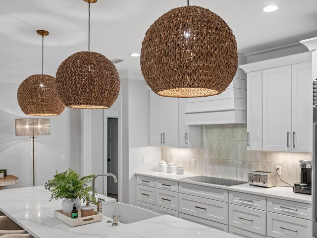 kitchen featuring tasteful backsplash, black electric stovetop, white cabinets, and sink