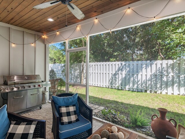 sunroom / solarium featuring ceiling fan and wooden ceiling