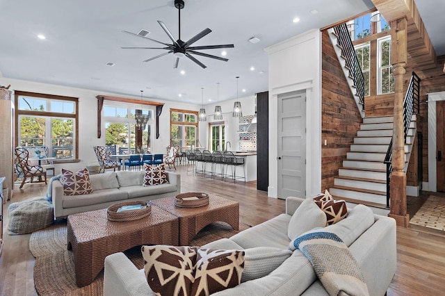 living room featuring light hardwood / wood-style flooring, a healthy amount of sunlight, and ceiling fan