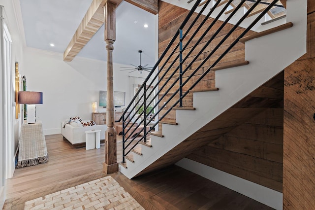 staircase with ornamental molding, hardwood / wood-style flooring, and ceiling fan