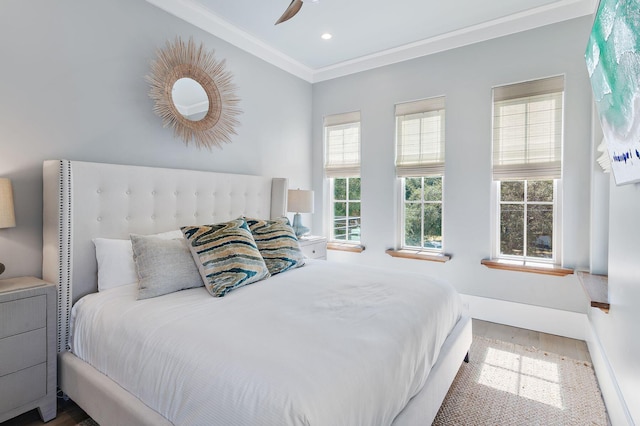 bedroom featuring ceiling fan, ornamental molding, and hardwood / wood-style floors