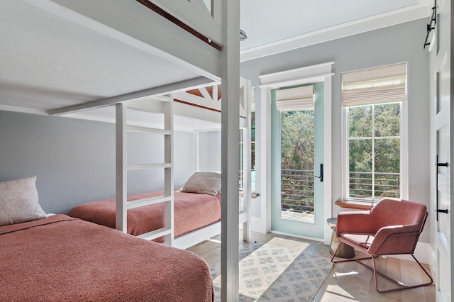 bedroom featuring a barn door, hardwood / wood-style flooring, and access to exterior