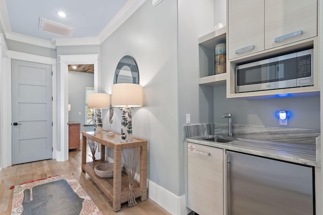 kitchen with sink, crown molding, appliances with stainless steel finishes, and light hardwood / wood-style flooring