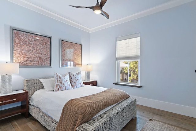 bedroom with hardwood / wood-style floors, crown molding, and ceiling fan