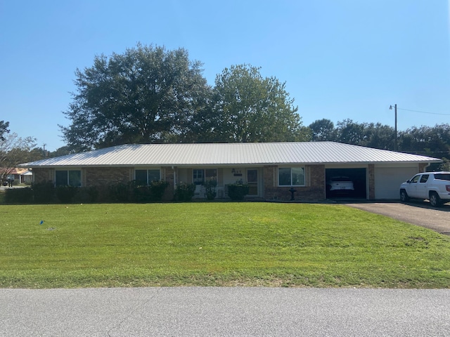 single story home featuring a garage and a front lawn