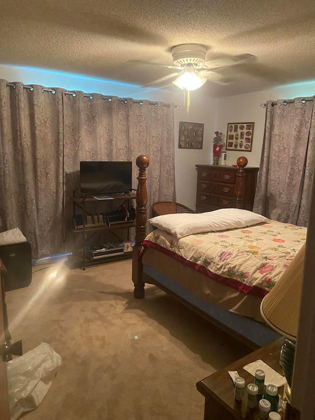 bedroom featuring ceiling fan, a textured ceiling, and carpet flooring