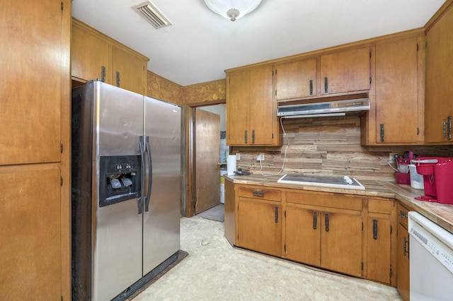 kitchen featuring backsplash, dishwasher, stainless steel fridge, and cooktop