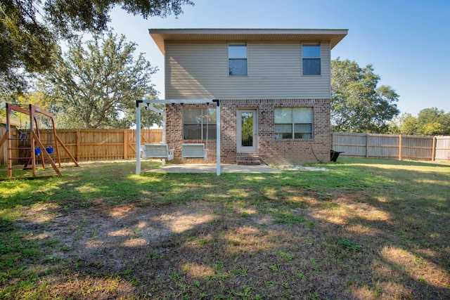 rear view of house featuring a yard, a playground, and a patio