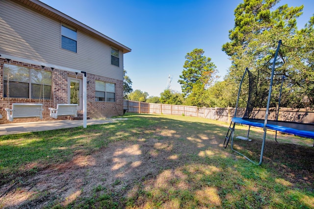 view of yard featuring a trampoline and a patio area