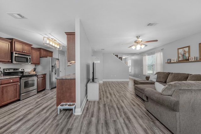 living area with light wood finished floors, ceiling fan, and baseboards