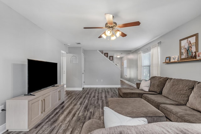 living area with wood finished floors, a ceiling fan, and baseboards