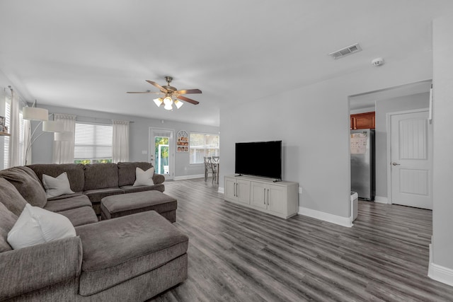 living room with baseboards, a ceiling fan, and wood finished floors