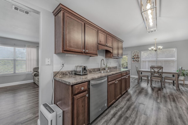 kitchen featuring stainless steel dishwasher, baseboards, a sink, dark wood-type flooring, and dark countertops