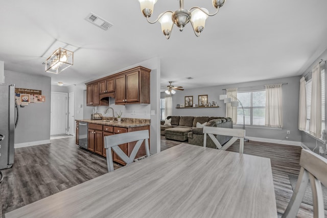 dining area featuring a chandelier, baseboards, dark wood-style floors, and ceiling fan