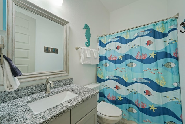 bathroom featuring a shower with curtain, vanity, and toilet